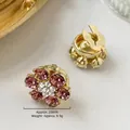 Vista detallada del gemelo floral dorado con pedrería púrpura y especificaciones - 23mm / Estilo de Flor Rosa Púrpura (E1621-6)