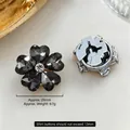 Detailed view of flower shaped cufflinks with black crystal petals and silver metal backing - 25mm