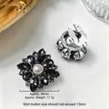 Gemelli a fiori eleganti con perla e cristalli neri su sfondo in marmo pregiato - 28mm