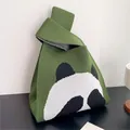 Macro detail of green knitted panda tote bag with unique knot handle and checkered lining - Green - Face-Covering Panda