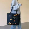 Large black canvas tote bag featuring autumn harvest illustrations and shoulder strap - Autumn Leaves / Black
