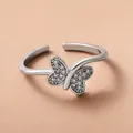 Silver adjustable butterfly ring with micro-set zircons on a light beige background - Nimble Butterfly Open Ring (M-651)