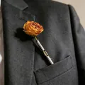 Eleganter silberner Vasen-Anstecknadel mit einer getrockneten orangefarbenen Rose am Revers - Rohrförmiger Spiral-Blumenhalter-Stil / Silber