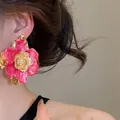 Orecchino a fiore rosa stropicciato in metallo smaltato indossato da modella asiatica - Orecchini (HE32791) / Rosa Rosso