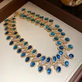 Luxuriöse Vintage Goldkette mit blauen ovalen Harzedelsteinen und funkelnden klaren Straßsteinen. - Blau