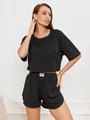Detail der gerippten schwarzen Lounge-Shorts mit weißem Fashion-Label am elastischen Bund - S / Schwarz