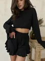 Detail of black ribbed lounge set featuring flared sleeves and ruffled shorts hem - S / Black