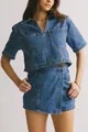 Detalle del conjunto vaquero azul vintage con botones metálicos y costuras de contraste - Conjunto de mezclilla azul