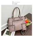 Camel colored leather handbag with decorative zippers and crossbody strap in a home setting - Camel