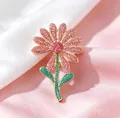 Detailaufnahme der Gänseblümchen-Brosche mit rosa Kristallen und Goldverzierung - Rosa Gänseblümchenstil