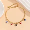 Nahaufnahme des goldenen Edelstahl-Fußkettchens mit bunten Evil-Eye-Anhängern und Metallrohren - Jl-004