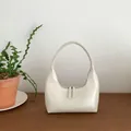 Minimalist white patent leather crescent bag with top handle and double zippers - White