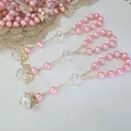 Pink pearl and crystal rosary bracelet with golden angel wings charms on white background - Pink Gold Wings