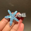 Blue resin starfish hair clip with faux pearls and crystals on a dark background - 7415 Iridescent Starfish Bead Hair Clip-Blue
