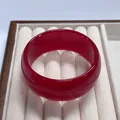 Polished wide red resin bangle with a smooth geometric finish on a velvet tray - Red