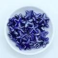 Macro detail of blue glazed starfish ceramic beads for DIY jewelry making in a white bowl - Royal Blue