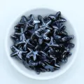 Macro shot of metallic starfish ceramic beads for DIY jewelry in a white bowl - Black