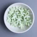 Close-up of pearlized light green starfish ceramic beads in a white bowl for DIY jewelry - Light Water Green
