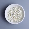 Macro shot of glazed starfish ceramic beads in a white bowl for DIY jewelry making - Off White