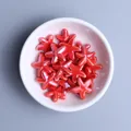 Vista macro di perle in ceramica a forma di stella marina rossa per gioielli fai da te - Rosso