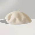 Nahaufnahme der cremeweißen Wollbaske mit dicker Textur und dem typischen Stiel oben - Einheitsgröße (56-59cm) / Gebrochenes Weiß