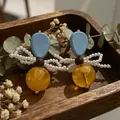 2605076 Pearl Bow Yellow Ball Earrings