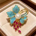 Broche de iris francés vintage con pétalos de turquesa azul y perla blanca sobre terciopelo - Estilo de Flor de Iris Retro Francés (X116969)