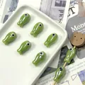 Macro detail of ceramic fish beads for DIY jewelry making on a decorative tray - Green