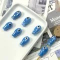 Detailed view of blue fish ceramic beads with glazed finish and large eye design on wood - Lake Blue