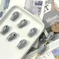Macro shot of fish-shaped ceramic beads for DIY jewelry making on white tray - Silver Grey