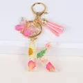 Detail of resin letter K keychain with real dried flowers, gold foil and pink tassel - Letter K