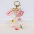 Detail of resin letter Q keychain with real dried flowers, pink tassel and butterfly - Letter Q