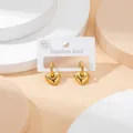 Polished gold heart drop earrings in stainless steel on a minimalist display - Heart Pendant / Gold