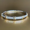 Dettaglio macro del bracciale bicolore con cristalli baguette e accenti a X in oro lucido - Bracciale Con Croce - Bicolore - Argento Con Dettagli Dorati - Taglia 3