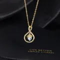 Close-up of golden graduation necklace with heart zircon and engraved quote - M