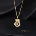 Detail of a gold graduation cap pendant with a starburst compass and zircon inlay - Letter R
