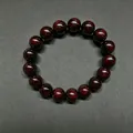 Sandalwood beaded bracelet with 15 natural dark red wood beads on a dark textured background - 12mm*17 Beads High Density Old Material