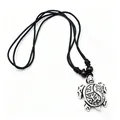 Close-up of turtle pendant with tribal patterns, black cord, and wooden beads decoration - Antique Silver