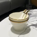 Modern white ceramic bowl set with gold rim detailing and matching spoons on marble - Gold Rim 2 Bowls and 2 Spoons Set