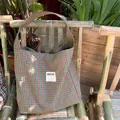 Green and purple plaid tote bag with See You patch on a bamboo chair outdoors - Green and Purple Plaid