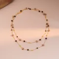 Detail of layered gold chain necklace featuring tiger eye beads and pearls on a stone - 6# Necklace-Gold-Brown