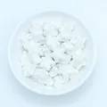 Macro shot of white glazed ceramic star beads for handmade jewelry in a white bowl - White