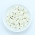 Close-up of creamy white star-shaped ceramic beads for DIY jewelry making - Off-white
