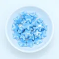 Macro view of light blue glazed star-shaped ceramic beads for DIY jewelry making - Lake Blue