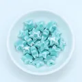Macro shot of glazed mint green star-shaped ceramic beads for DIY jewelry making - Blue Howlite
