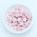 Macro shot of light pink star ceramic beads for handmade jewelry DIY in a white bowl - Light Pink