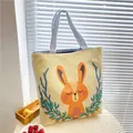 Beige canvas tote bag with orange cartoon rabbit print and blue striped handles - Sleeping Rabbit