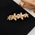 Elegant gold flower spring hair clip with four detailed floral motifs on black fabric - Gold-colored Four-flower Spring Clips
