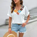 T-shirt bianca da donna con scollo a V e decorazioni colorate all'uncinetto stile boho - XL / Bianco