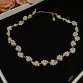 Vintage pearl necklace with gold beads and flower cluster design on black velvet - Gold-White